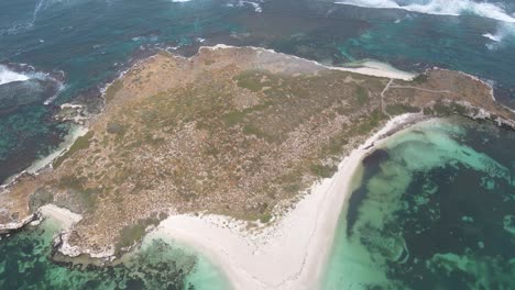 Aerial-top-down-shot-of-Australian-deserted-island-with-crashing-waves-during-sunlight