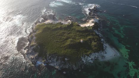 Aerial-top-down-shot-of-Australian-green-island-with-crashing-waves-during-sunlight