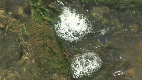 Close-up-of-small-eddies-of-bubbles-rotating-in-opposite-directions-in-a-stream