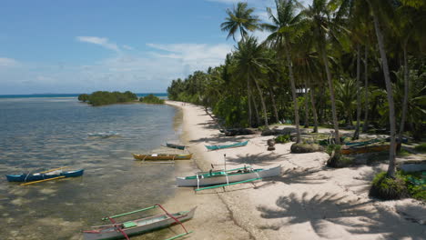 Antenne-Zeigt-Hölzerne-Fischerboote-Am-Union-Beach,-Siargao-Island,-Philippinen