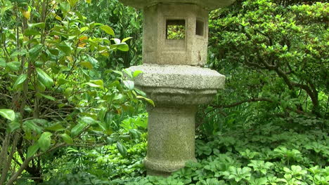 Kamera-Schwenkt-Vom-Regenwasserbecken-Zur-Steinlaterne-Im-Japanischen-Garten