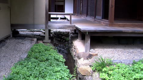 Camera-jibs-down-from-Japanese-house-to-rainwater-gully-and-yew-bush