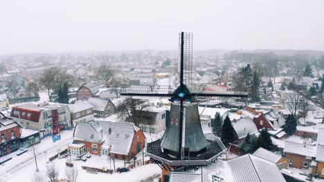 Holländisches-Dorf-Und-Windmühle-In-Verschneiter-Winterlandschaft,-Drohnenluftbild