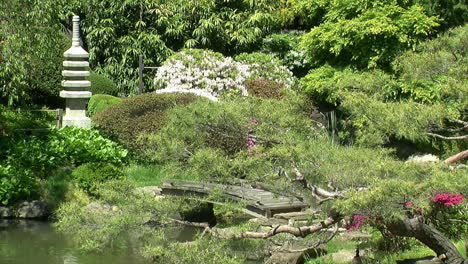 Eine-Steinpagode-Und-Eine-Fußgängerbrücke-In-Einem-Japanischen-Garten