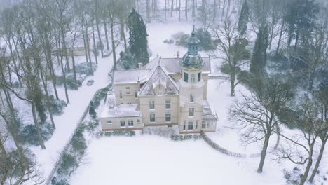 Aerial-View-of-an-Old-Groevenbeek-Church-in-Netherlands,-Winter-Scene-with-Falling-Snow