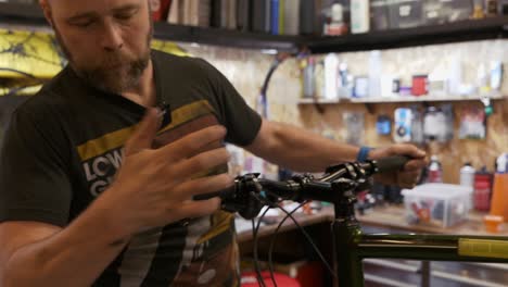 A-male-bike-mechanic-fits-new-bar-end-stoppers-in-a-workshop