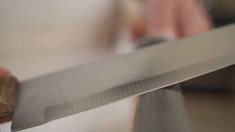 Sharpening-Knife-on-Round-Seam,-Slow-Motion-Towards-Camera,-Copy-Space