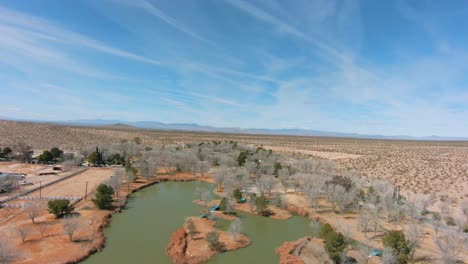 Flying-fast-in-a-FPV-drone-over-a-park-with-a-pond-in-the-Mojave-Desert
