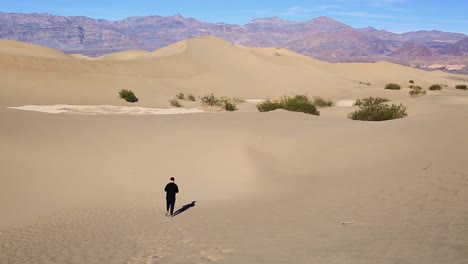 Mann-Geht-Und-Hinterlässt-Fußspuren-Auf-Sanddünen-Im-Death-Valley,-Kalifornien