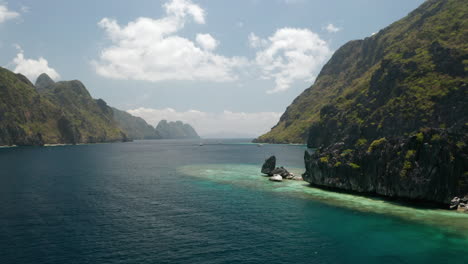 Aerial-panning-shot-revealing-the-bay-of-Matinloc-Island,-El-Nido,-Palawan,-Pilippines