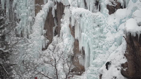 Ice-Climber-on-Frozen-Waterfall-in-Ouray-Ice-Park,-Colorado-USA-Slow-Motion-Wide-View