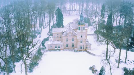 Static-aerial-view-of-blizzard-and-snow-capped-mansion-in-rural-Netherlands