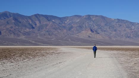 Man-Walking-At-Badwater-Basin,-Death-Valley-National-Park,-California,-USA