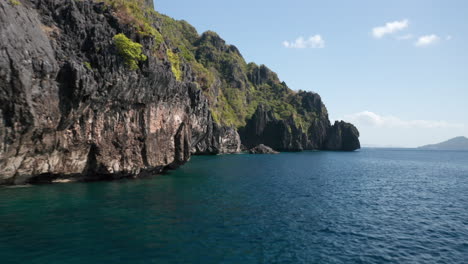 Drone-shot-over-water-showing-cliffs-en-rocks-on-Matinloc-Island,-El-Nido,-Palawan,-Philippines