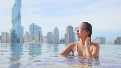 Pretty-Woman-in-Rooftop-Swimming-Pool,-MahaNakhon-Skyscraper-Backdrop