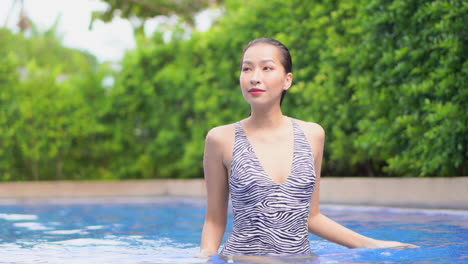 Sophisticated-Asian-Woman-Walking-Sensual-in-Swimming-Pool-SLOMO