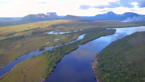 Drone-view-of-the-Carrao-river-in-Canaima,-Venezuela,-with-beautiful-skies-and-savannas-at-the-back
