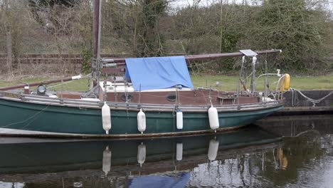 Classic-old-sailboats-moored-on-narrow-rural-countryside-canal-marina