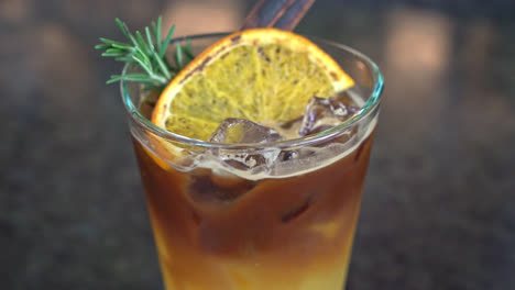 orange-and-lemon-juice-soda-topped-with-black-coffee-in-glass-with-rosemary-and-cinnamon