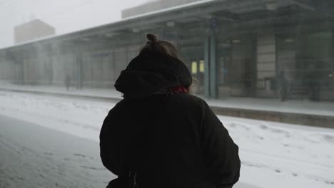 Woman-waiting-for-train-in-snowstorm-in-Helsinki