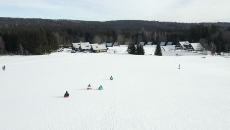 Aerial-Shot-Of-Children-Sledding-On-A-Ski-Hill-At-A-Winter-Ski-Camp-In-Czech-Republic
