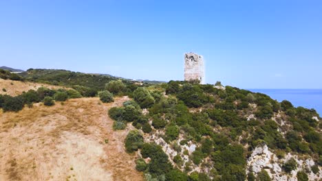 Sich-Aufwärts-Bewegende-Luftdrohne-Schneidet-über-Einen-Sandstrand-In-Richtung-Eines-Alten-Turms-In-Kavala,-Mazedonien,-Griechenland