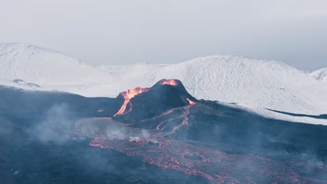 Erupción-Fagradalsfjall-En-Islandia-Con-Montañas-Cubiertas-De-Nieve-En-El-Fondo