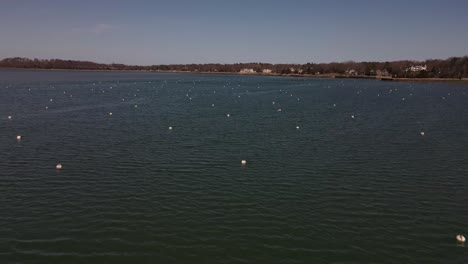 Drone-flight-low-over-Hingham-Harbor-moorings-on-a-warm-spring-day