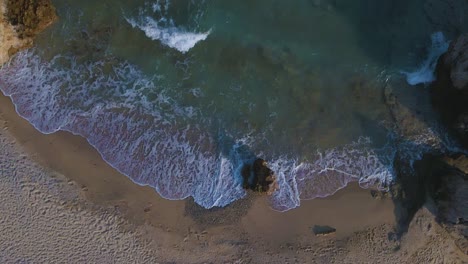 Slomotion-aerial-drone-clip-moving-over-a-sandy-beach-and-a-rock-formation-in-Kavala,-Macedonia,-Greece