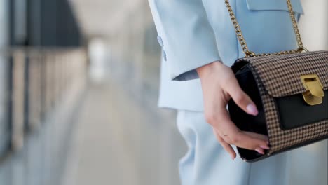 Close-up-of-a-women's-handbag-on-a-girl-in-a-blue-suit