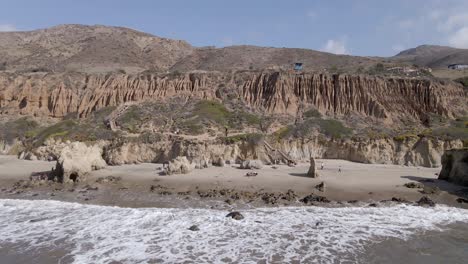 Malerischer-Blick-Auf-Klippen,-Berge-Und-Meereswellen,-Die-Am-Ufer-In-El-Matador-Beach,-Malibu,-Kalifornien,-Vereinigte-Staaten---Luftrückzug