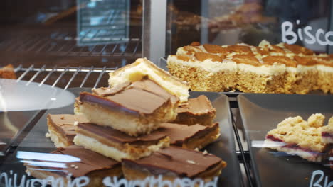 Carrot-cakes,-flapjacks,-caramels-slices-and-walnut-cake-deserts-in-a-cafe-restaurant-counter-bar-display-case
