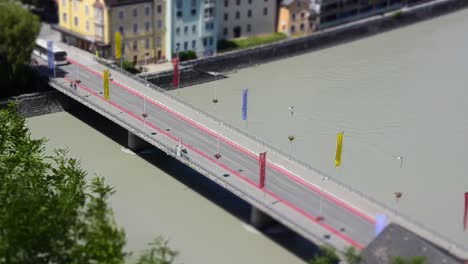 Miniature-scene-of-a-timelapse-of-a-bridge-over-a-river-with-buses-and-cars-driving-over-it-in-a-small-city