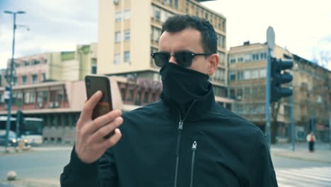 Man-In-Street-At-Day-with-mask-Stands-In-Front-Of-Camera-4K