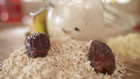 Dried-Date-Fall-into-Pile-of-Oat-Flakes,-Selective-Focus-with-Copy-Space