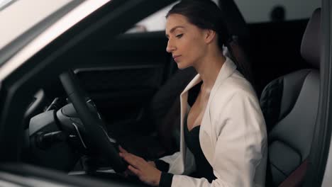 Stylish-business-woman-driving-a-car-posing-in-front-of-the-camera