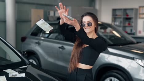 Happy-smiling-attractive-girl-scattering-banknotes-money-on-the-car
