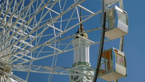 Podil-Ferris-Wheel-in-Kiev-spins-with-spire-of-St-Catherine-Church-on-a-sunny-autumn-day