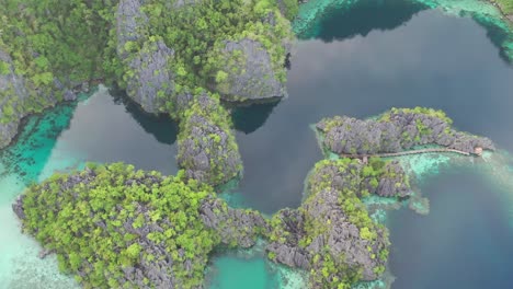 Drone-view-of-limestone-karst-scenery-and-turquoise-ocean-water-in-Coron-Island,-Palawan,-Philippines