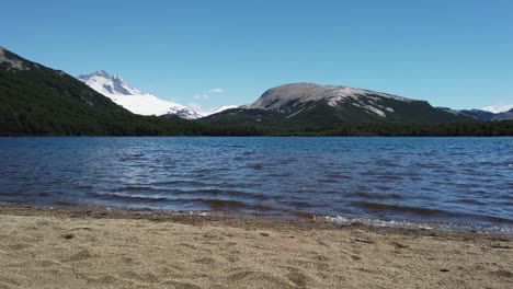 Coarse-sand-beach,-deep-blue-water-and-clear-mountain-air-in-Laguna-Ilon,-Bariloche
