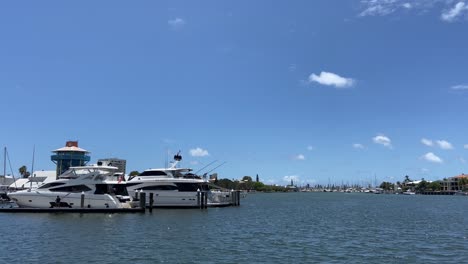 A-peaceful-marina-with-sleek-white-cruiser-baots,-under-perfect-blue-summer-skies