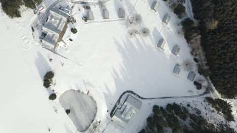 Luftaufnahme-Des-Winterskilagers-Mit-Hütten,-Schneebedeckte-Alpenlandschaft