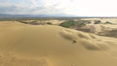 Aerial-view-of-a-Boogie-car-jumping-the-sand-dunes-in-Medanos-de-Coro,-Falcon,-Venezuela