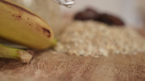 Close-up-of-Bananas,-Oat-Flakes,-Dried-Dates-and-Vanilla-Powder-on-Rotating-Surface