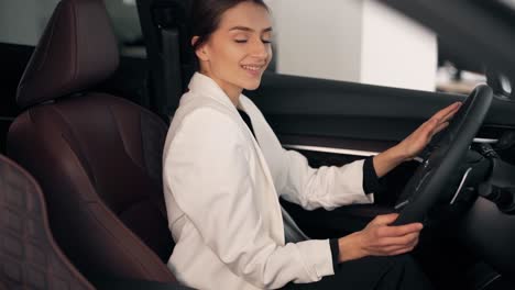 Beautiful-smiling-girl-driving-a-luxury-car-with-a-leather-interior