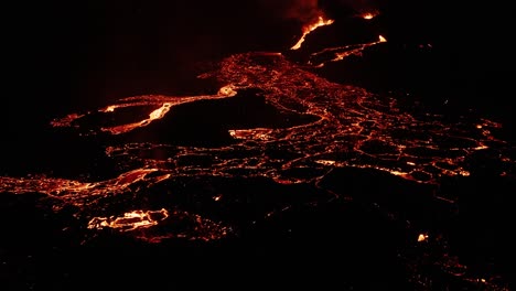 Iceland-lava-field-with-molten-magma-flowing-as-rivers-on-dark-surface-at-night