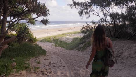 Kaukasische-Frau,-Die-Am-Sandigen-Bergab-Geht,-Dreht-Sich-Um-Und-Gestikuliert,-Am-Strand-Mitzukommen---Main-Beach-Landlandreserve-In-Point-Lookout,-Qld,-Australien