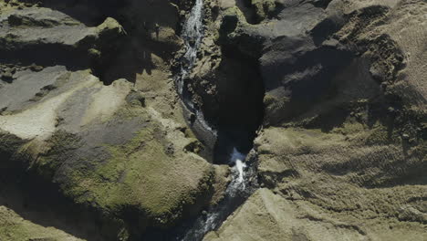 Aerial-View-Of-Kvernufoss,-Massive-Waterfall-Rushing-Over-Sheer,-Moss-Covered-Cliffs-In-South-Iceland