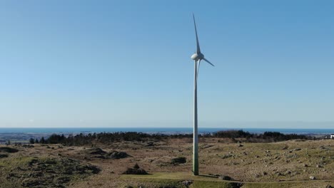 Windkraftanlage-Am-Meer,-Drohnenluftbild-An-Einem-Sonnigen-Tag,-Alternatives-Nachhaltiges-Energiekonzept,-Orbit-drohnenschuss