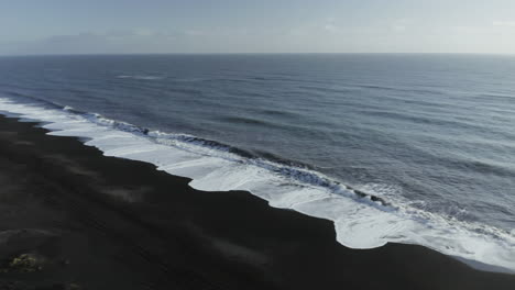Big-Foamy-Waves-Splashing-On-Black-Sand-Beach-In-Iceland---panning-shot